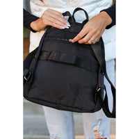black quilted backpack with gold zipper detail worn by woman stylish everyday backpack